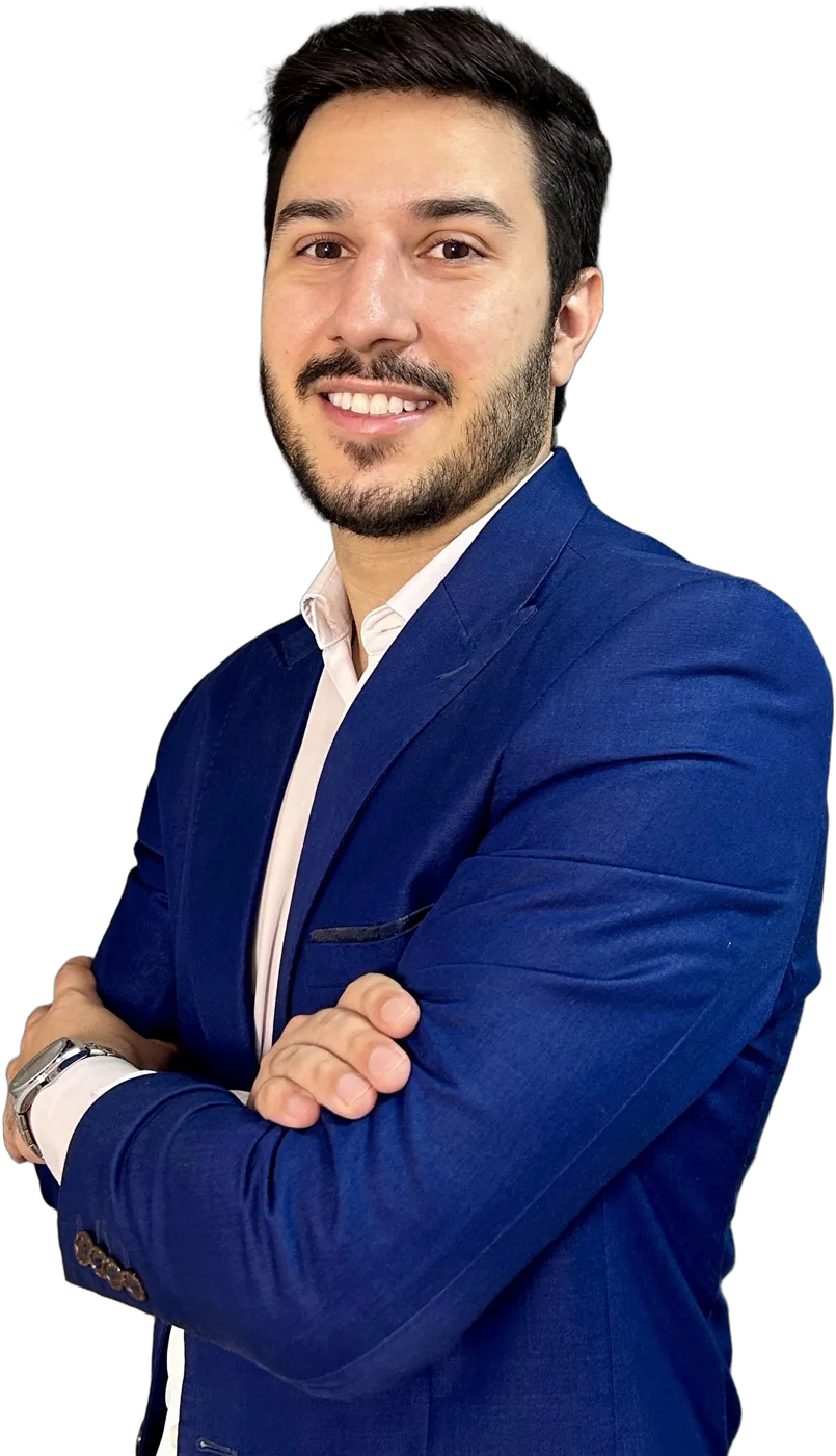 Bruno de Oliveira, de terno azul, sorrindo com os braços cruzados